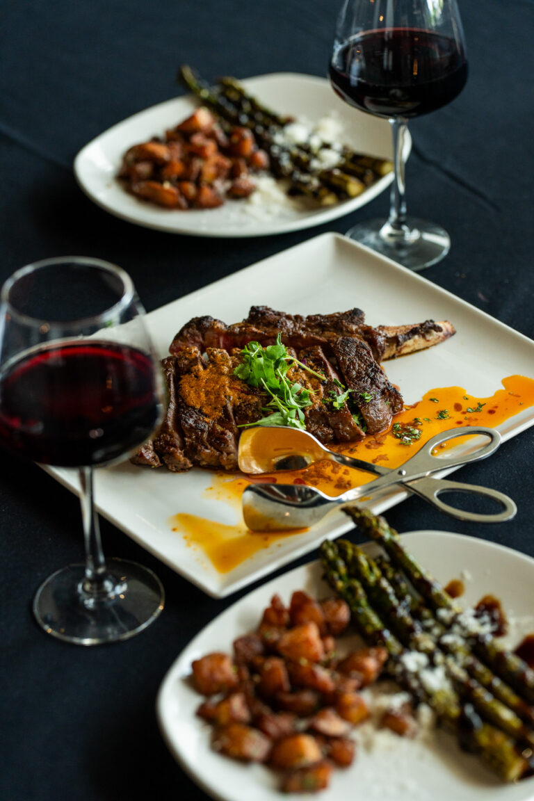 Shared steak dinner, paired with red wine, crispy potatoes, and grilled asparagus